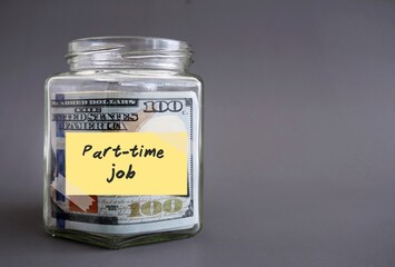 Money glass jar bottle filled with cash dollars money with label PART-TIME JOB, concept of make more income by side job, second gig or side hustle in spare time after work hours
