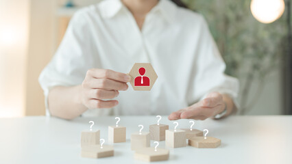 Select people to be leaders match abilities skills expertise. Woman holds a hexagonal wooden block...