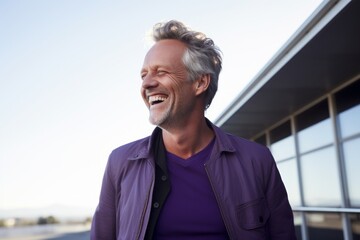 Portrait of handsome middle-aged man laughing and looking away outdoors
