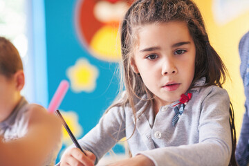 Cute girl drawing in the classroom