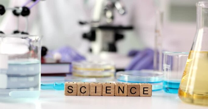 Word science with microscope and liquids in flask. Science education and laboratory research and development concept