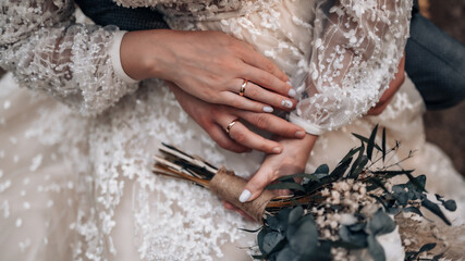 Young married couple holding hands, ceremony wedding day. Groom holding bride's hand, close up