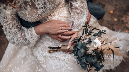 Young married couple holding hands, ceremony wedding day. Groom holding bride's hand, close up