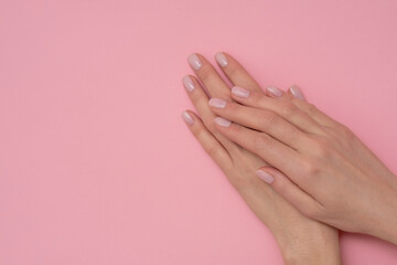 Natural manicure on pink background.