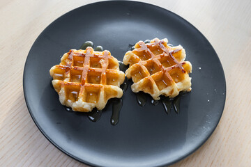 Two mini waffles with syrup.