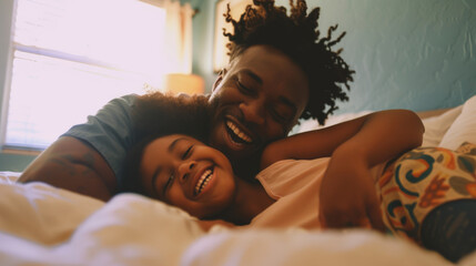 African American father and daughter enjoying a playful moment in bed
