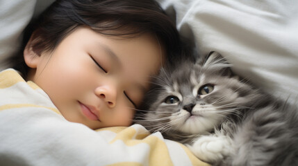 Small Asian child lies on a bed with a cat. Kitten and baby childhood friendship. Baby and cat. Child and Kitten lying together on the bed