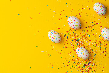 Sprinkle painted easter eggs on yellow background