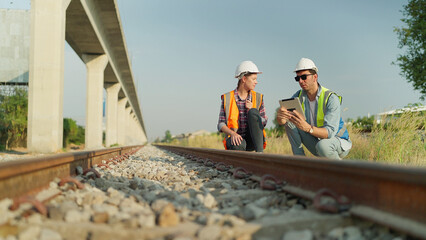 Two engineers in safety uniform and helmet using tablet discussion and inspection construction...