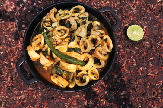 Indian Spicy Squid Masala. Konkani Calamari Dry. Main Course Seafood recipes. Tender squid cooked with aromatic spices like cumin, coriander, and chili powder, saut&eacute;ed with onions and garlic.