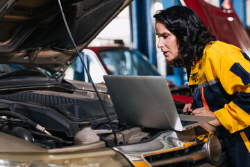auto mechanic car engineer using laptop computer tuning ECU diagnosis analysis monitor engine problem in garage auto service