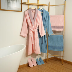 Bathrobe set - Hanger with clean bathrobe and towel on light wall bathrobe mockup