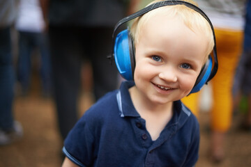 Portrait, child and noise cancelling headphones at outdoor event with smile, fun and music....