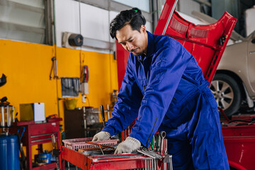 Asian Japanese male mechanic worker portrait in auto service workshop car maintenance center...
