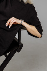 Hands of a girl in black clothes on a light background
