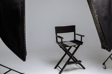 Director's chair in photo studio with laptop and flashes