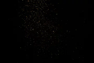Foto op Plexiglas group of small golden flakes are scattered on the black surface © noppadon
