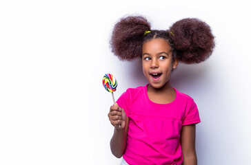 Girl afro, lollipops. Smile little american girl eating lollipop, holding pink sweet colorful lollipop candy, sweets. Funny african child with candy lollipop, happy little girl eating sugar lollipop