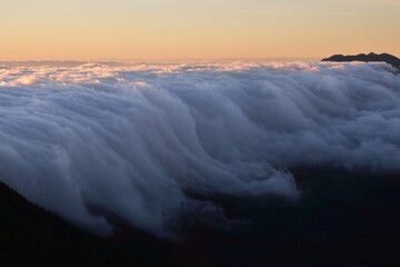 Sunrise in mountains with inversion phenomenon and low clouds lit by sun. Refugio Punta de Los Roques, National Park Caldera de Taburiente, La Palma, Canary Islands, Spain