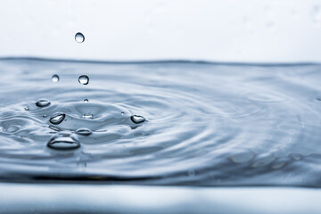 Vibrant water droplets reflecting on a pristine white background, creating captivating splashes and...