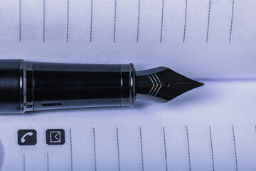 Close-up of an elegant fountain pen resting on an open calendar. Perfect for articles on time...