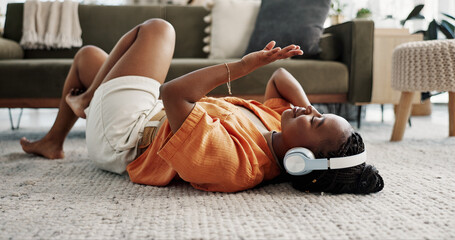 Music, headphones and black woman on floor, listening to song and audio in living room. Happy...