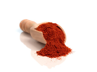 red pepper powder on a wooden spoon, reflected in the white base