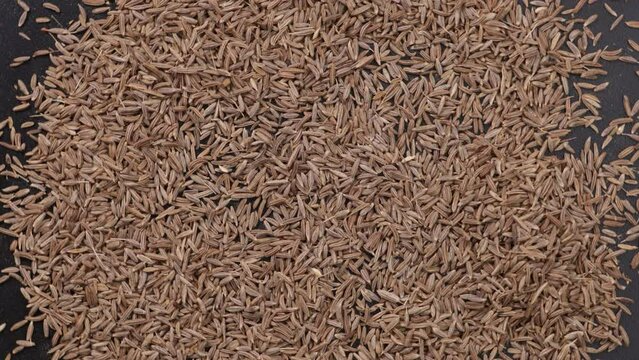 cumin top view on black surface