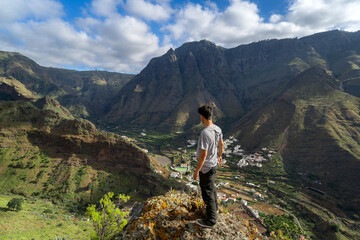 Young man contemplates the landscape. Agaete Valley. Gran Canaria. Canary Islands - obrazy, fototapety, plakaty