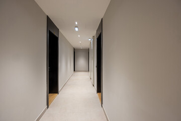 Interior of a long corridor with apartment doors