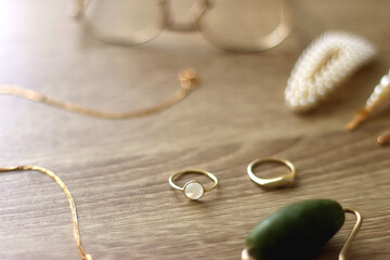 Pearl headband and barrette, golden eyeglasses, gold necklace, earrings and rings, jade face roller...