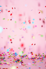 festive confetti in front of a colorful pink rose background