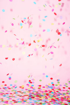 festive confetti in front of a colorful pink rose background