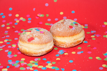 Traditional German Carnival Sweets  Berliner, Pfannkuchen or Krapfen in front of a colourful background