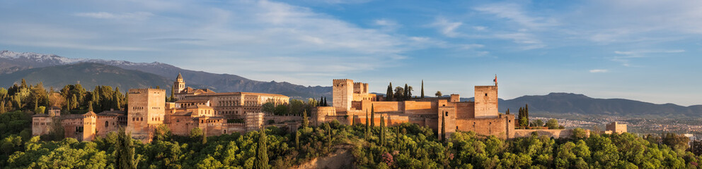 Panoramic sunset hour time of Alhambra medieval palace and fortress complex with Sierra Nevada...