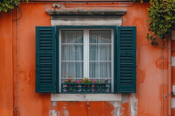 Fototapeta na wymiar A window with green shutters on an orange building. Suitable for architectural or travel-related projects