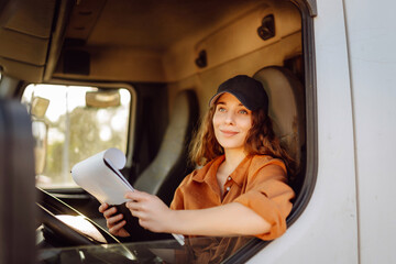 Female driver looking out of truck window. Transport industry theme