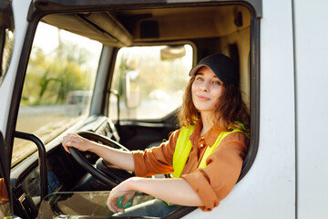 Female driver looking out of truck window. Transport industry theme