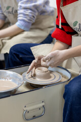 The student forms her first cup on the potter's wheel