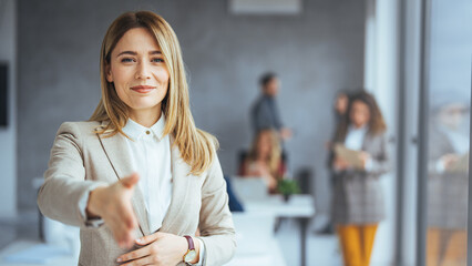 Happy office employee giving hand for shaking . Arm of business woman offering handshake....