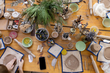 work table with tools and blanks during a master class in a pottery workshop. Top view - obrazy, fototapety, plakaty