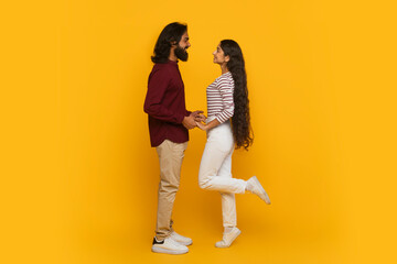 Fototapeta na wymiar Emotional young indian couple have date, yellow background