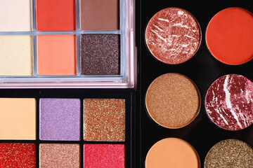 Various colorful eyeshadow palettes on bright pink background. Flat lay.
