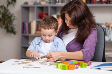 Fototapeta premium Teacher learning little child in classroom. Preschool education concept