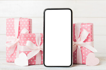mobile phone with blank screen on colored background with hearts, calendar and gift box, valentine day concept perspertive view flat lay