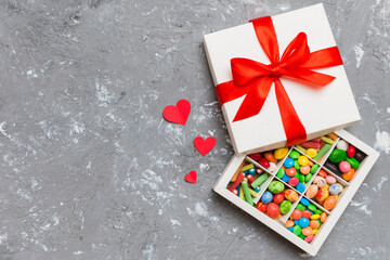 Valentine day composition: sweet candy, with gift boxes with bow and red felt hearts, photo...