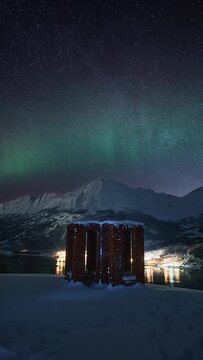 Sculpture on an overlook in Helgeland, with a view to the milky way and an aurora above a snowy mountainous landscape. The andromeda galaxy is also visible to the left side near the end of the video.