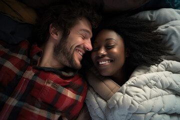 Couple laying in bed smiling to each other