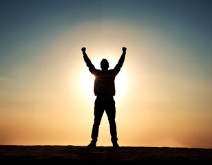 Fototapeta na wymiar Silhouette of a person with both arms raised in victory. Concepts of success and achievement.
