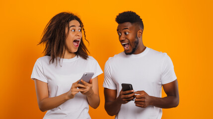 Fototapeta premium young man and woman are both holding smartphones and smiling at each other, with a bright orange background
